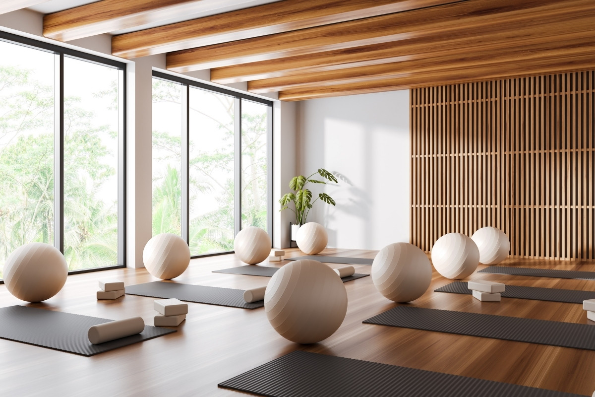 White and wooden yoga studio corner with mats and fitballs