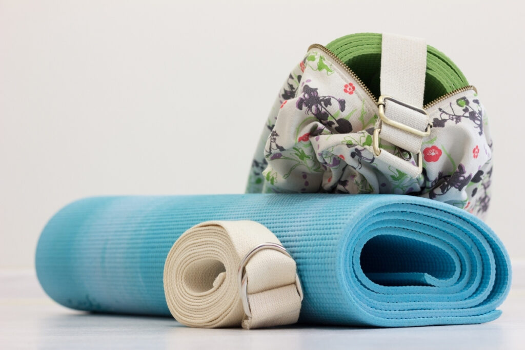 Blue yoga mat, strap and green yoga mat in the bag