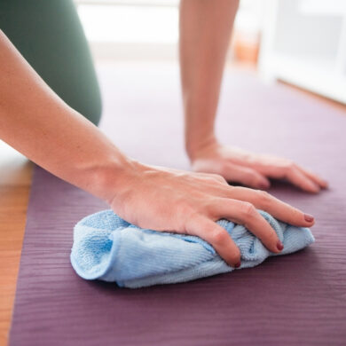 Woman Uses Hand Towel to Wipe Yoga Mat Clean at Home