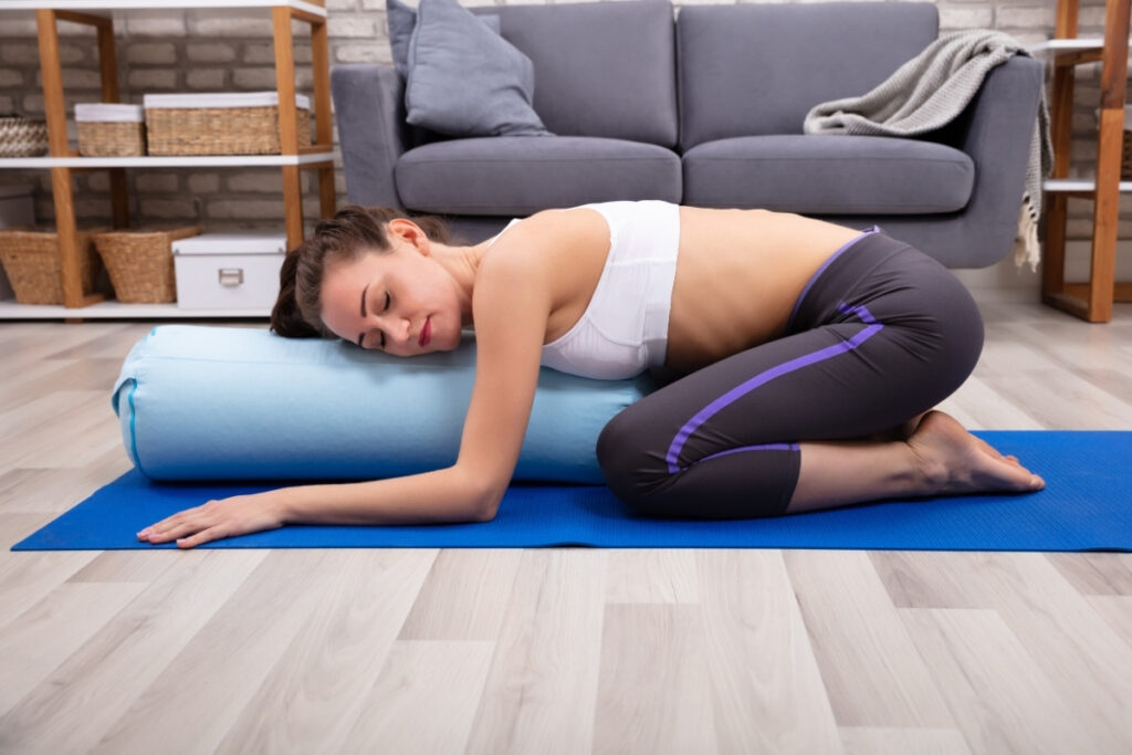 Young Woman Practicing Yoga With Bolster