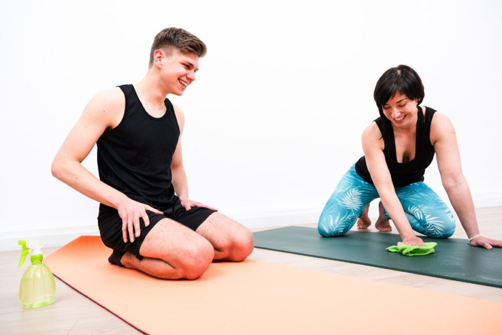 yoga class participants wiping yoga mats