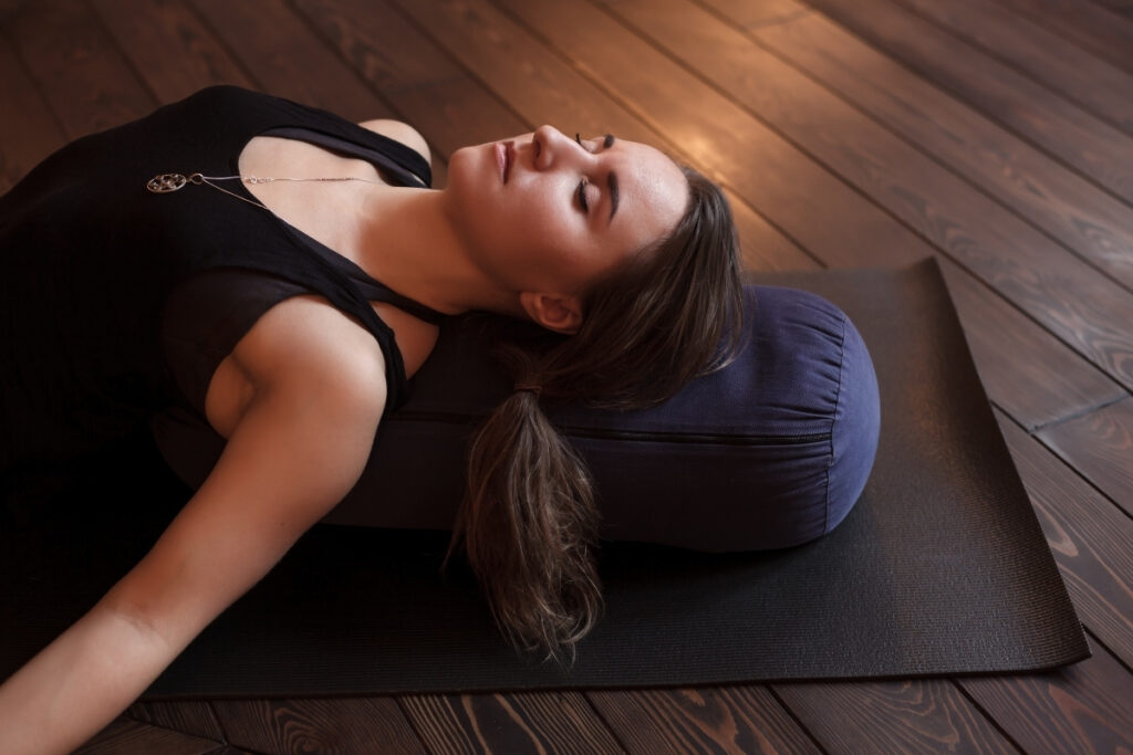 yoga retreat participant relaxing on a yoga bolster